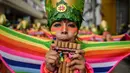 Peserta mengenakan kostum dan riasan memaikan alat musik tiup saat parade Canto a la Tierra di Pasto, Kolombia (3/1). Parade ini terdiri dari perpaduan budaya Andes, Amazon dan Pasifik. (AFP Photo/Luis Robayo)