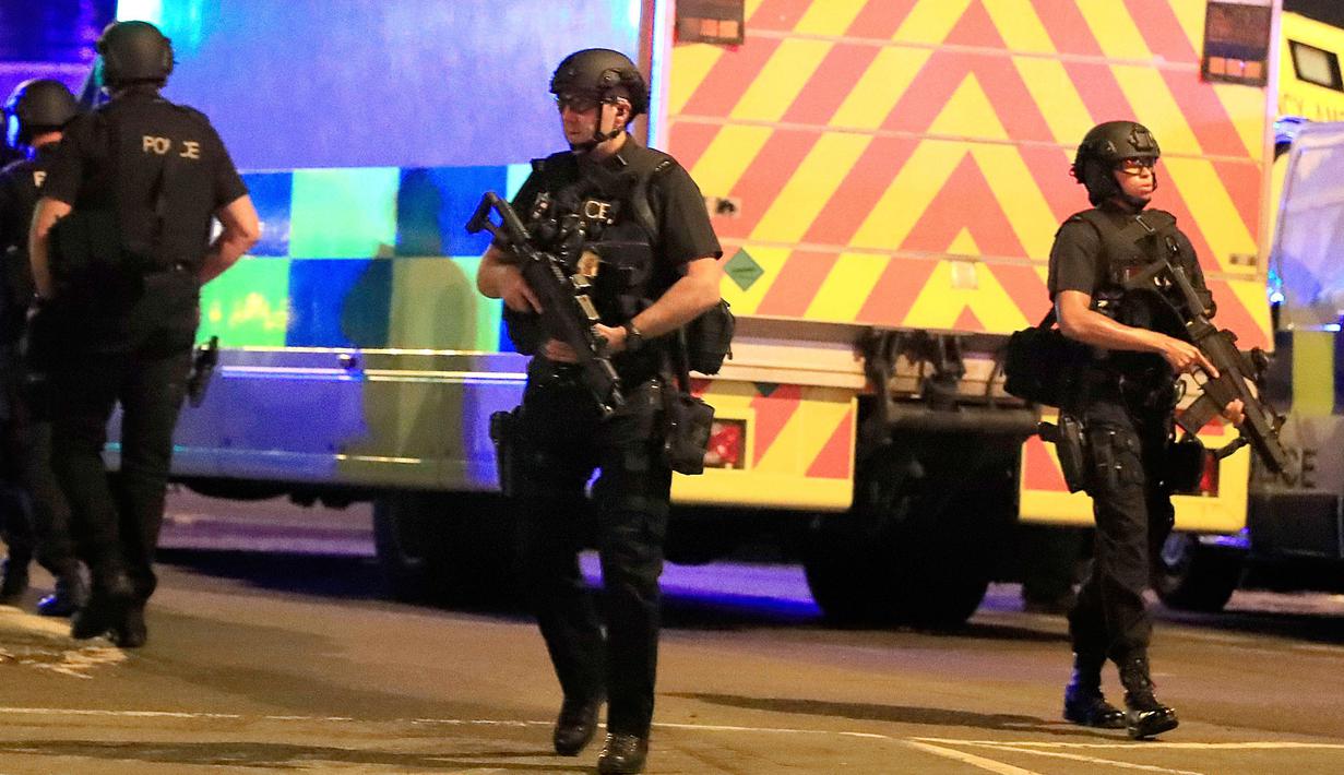 Polisi bersenjata mengamankan lokasi terjadinya ledakan usai konser penyanyi Ariana Grande di Manchester Arena, Inggris, Senin (22/5). Ledakan mengakibatkan stasiun kereta Manchester Victoria yang tak jauh dari lokasi ditutup. (Peter Byrne/PA via AP)