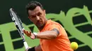 Mantan kapten AC Milan, Paolo Maldini mengembalikan bola ke arah lawan pada laga ganda putra ATP Challenger Tour di Aspria Tennis Club, Milan, (27/6/2017). Maldini kalah 1-6, 1-6. (AFP/ Marco Bertorello)