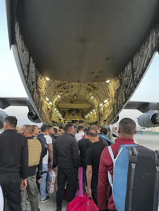 Warga negara India bersiap untuk menaiki pesawat militer India untuk dievakuasi setelah pengambilalihan Afghanistan oleh pejuang Taliban di bandara di Kabul (17/8/2021). Sebagian kecil warga India tetap di negara tersebut dan tengah diupayakan untuk dibawa kembali oleh pihak berwenang. (AFP Photo)