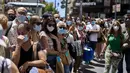 Orang-orang yang memakai masker berdiri di sepanjang jalan di Madrid, Spanyol, Kamis (24/6/2021). Spanyol melonggarkan aturan pandemi COVID-19, mengizinkan orang berhenti mengenakan masker di luar ruangan dan mengizinkan penggemar olahraga kembali ke dalam stadion.  (AP Photo/Manu Fernandez)