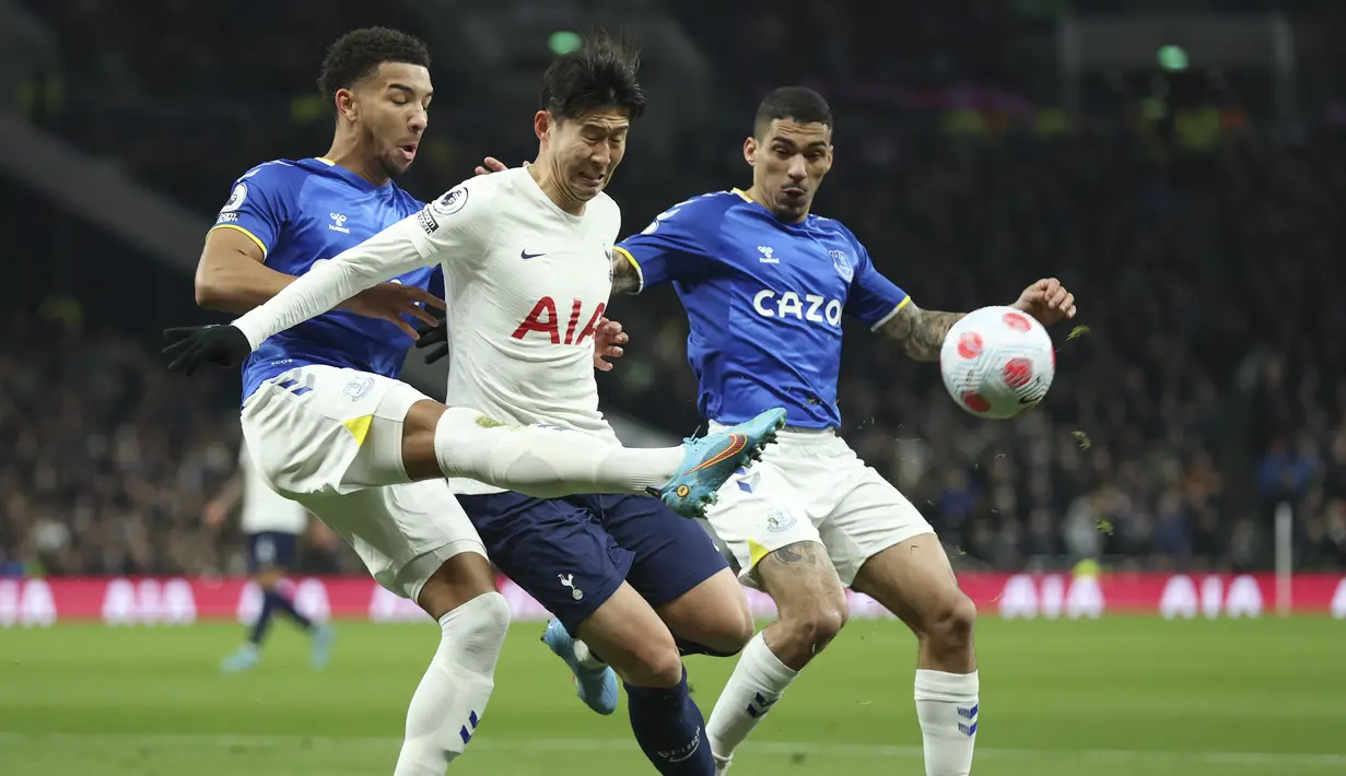 Penyerang Tottenham Hotspur Son Heung-min berebut bola dengan bek Everton Mason Holgate pada pekan ke-28 Liga Inggris 2021-2022 di Tottenham Hotspur Stadium, Selasa (8/3/2022) dini hari WIB. Tottenham Hotspur tanpa ampun menghajar Everton lima gol tanpa balas. (AP Photo/Ian Walton)