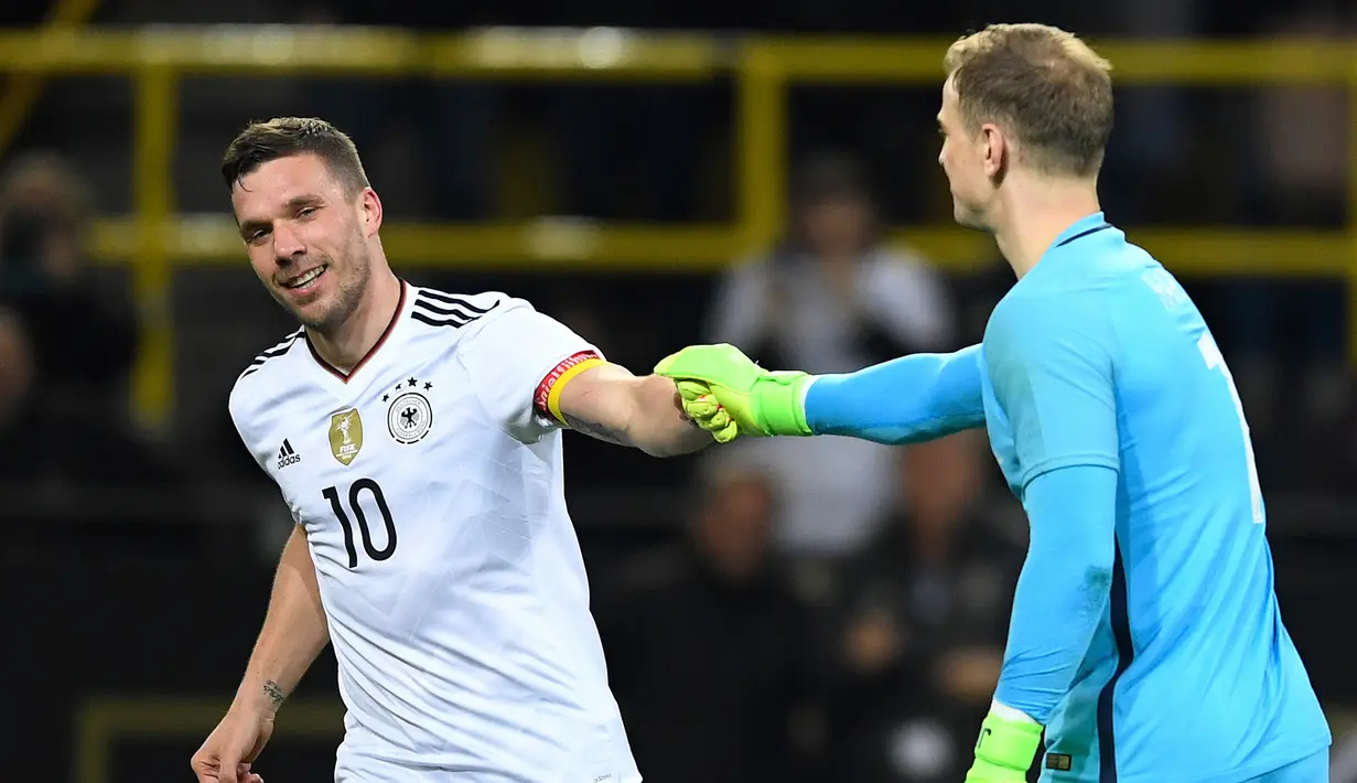 Penjaga gawang Inggris, Joe Hart memberi selamat kepada pemain Jerman, Lukas Podolski, dalam pertandingan persahabatan di Dortmund, (23/3). Podolski menjalani debutnya bersama timnas jerman dengan kekalahan. (Marius Becker/dpa via AP)