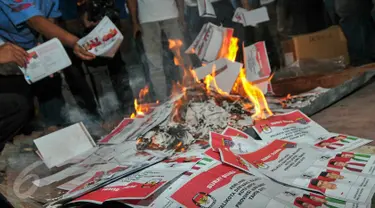 Anggota KPU Depok memusnahkan ratusan suara rusak dan kelebihan di Gudang Logistik KPU Depok, Selasa (8/12). Sebanyak 1576 surat suara yang terdiri dari 398 rusak dan 1178 kelebihan tersebut di musnahkan dengan cara dibakar. (Liputan6.com/Yoppy Renato)