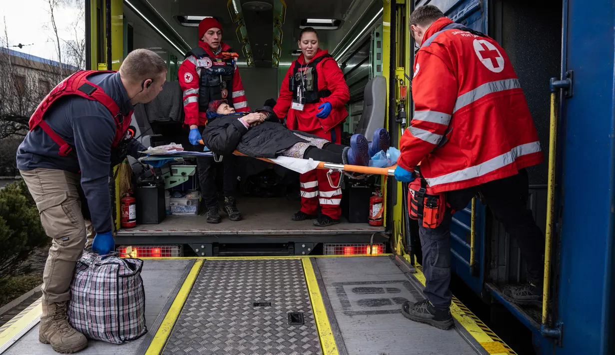 Relawan Palang Merah membawa seorang wanita dengan tandu ke kereta medis Medecins Sans Frontieres (MSF) atau Doctors Without Border saat mengevakuasi pasien dari dekat garis depan pertempuran ke daerah yang lebih aman di stasiun kereta di Pokrovsk, Ukraina, 7 Maret 2023. MSF merupakan kereta medis khusus yang dapat membawa pasien dari bagian timur Ukraina ke rumah sakit di bagian barat. (AP Photo/Evgeniy Maloletka)