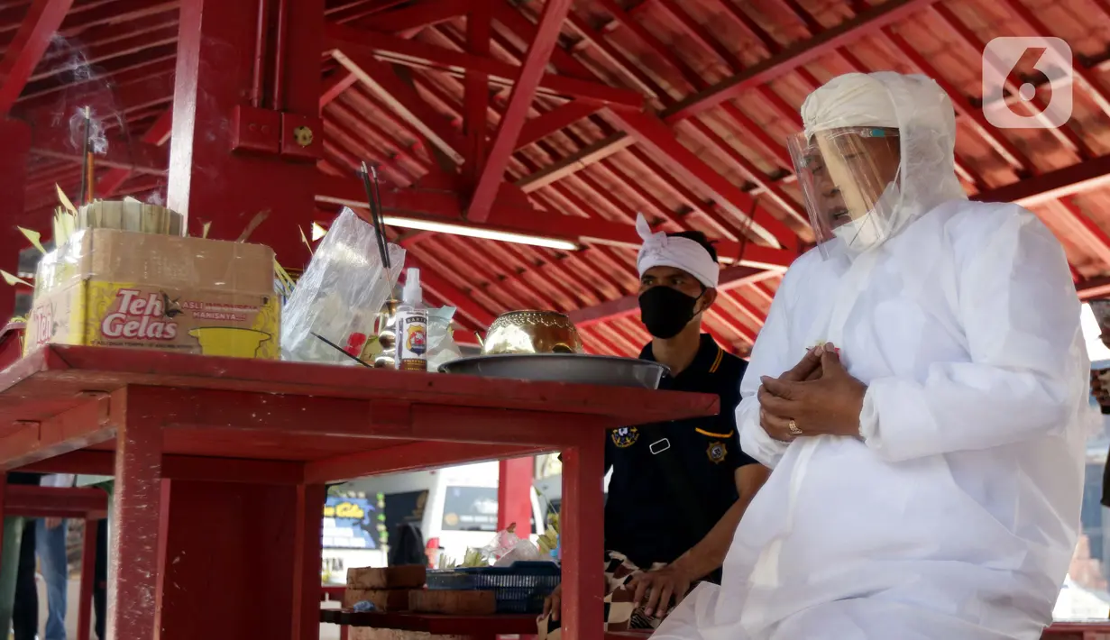 Pemuka agama memimpin doa untuk jenazah yang akan dikremasi di Krematorium Cilincing, Jakarta, Kamis (29/7/2021). Proses kremasi jenazah di Krematorium Cilincing masih menggunakan cara tradisional menggunakan kayu bakar dan membutuhkan waktu sekitar dua jam. (Liputan6.com/Helmi Fithriansyah)