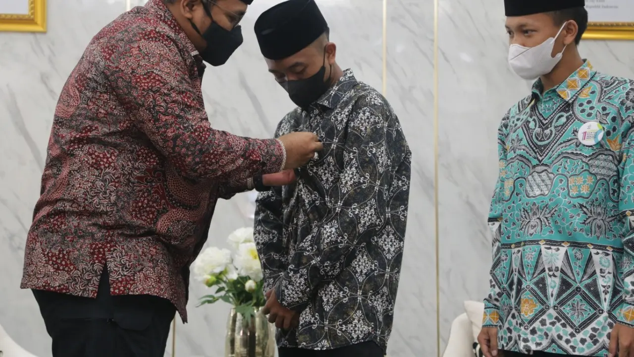 Yaqut Cholil Qoumas menyematkan pin Menteri Agama kepada pemenang Sayembara Santri Sehari Menjadi Menteri Agama Afi Ahmad Ridlo