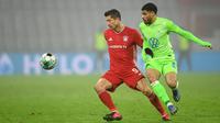 Penyerang Bayern Munchen, Robert Lewandowski, berebut bola dengan bek Wolfsburg, Paulo Otavio, pada laga lanjutan Liga Jerman di Allianz Arena, Kamis (17/12/2020) dini hari WIB. Bayern Munchen menang 2-1 atas Wolfsburg. (AFP/Christof Stache/pool)