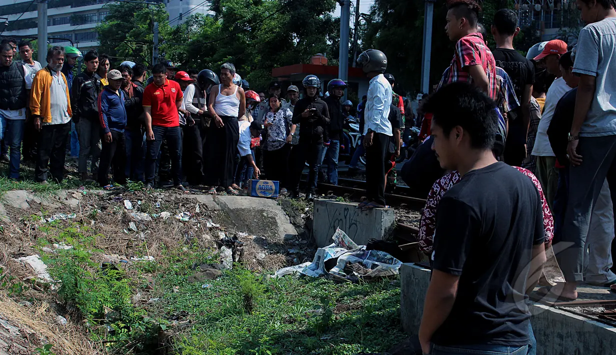 Puluhan warga berkerumun melihat jenazah seorang pria tewas tertabrak kereta api di dekat Stasiun Palmerah, Jakarta, Jumat, (8/5/2015). (Liputan6.com/JohanTallo)