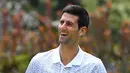 Petenis Serbia, Novak Djokovic memegang piala juara tunggal putra Australia Terbuka 2020 saat sesi pemotretan di Royal Botanic Gardens Victoria, Melbourne, Australia, Senin (3/2/2020). Bagi Novak Djokovic, ini merupakan gelar Australia Terbuka kedelapan. (Photo by William WEST / AFP)