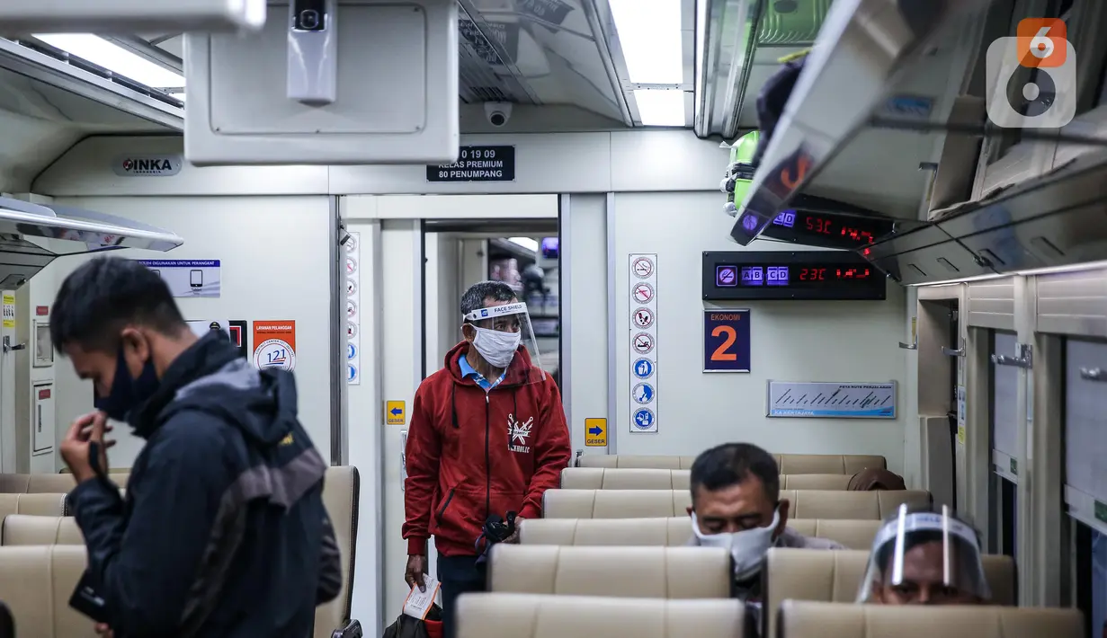 Penumpang menggunakan pelindung wajah berada di kereta jarak jauh di Stasiun Pasar Senen, Jakarta Pusat, Jumat (10/7/2020). PT. KAI membagikan face shield kepada penumpang bertujuan memudahkan masyarakat tetap dapat menjaga physical distancing di tengah pandemi COVID-19. (Liputan6.com/Faizal Fanani)