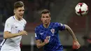 Pemain Kroasia, Mario Mandzukic berebut bola dengan pemain Yunani, Panagiotis Retsos pada laga leg kedua play-off Piala Dunia 2018 di Stadion Karaiskakis, Senin (13/11). Timnas Kroasia berhasil memastikan langkah ke Piala Dunia 2018. (AP/Yorgos Karahalis)