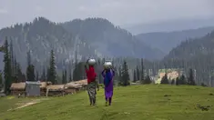 Gadis-gadis penggembala Kashmir berjalan pulang setelah mengambil air dari mata air terdekat di Tosamaidan, barat daya Srinagar, Kashmir yang dikuasai India, Senin (21/6/2021).  Padang rumput Tosamaidan ini dulunya merupakan tempat tembak artileri tentara India. (AP Photo/Dar Yasin)