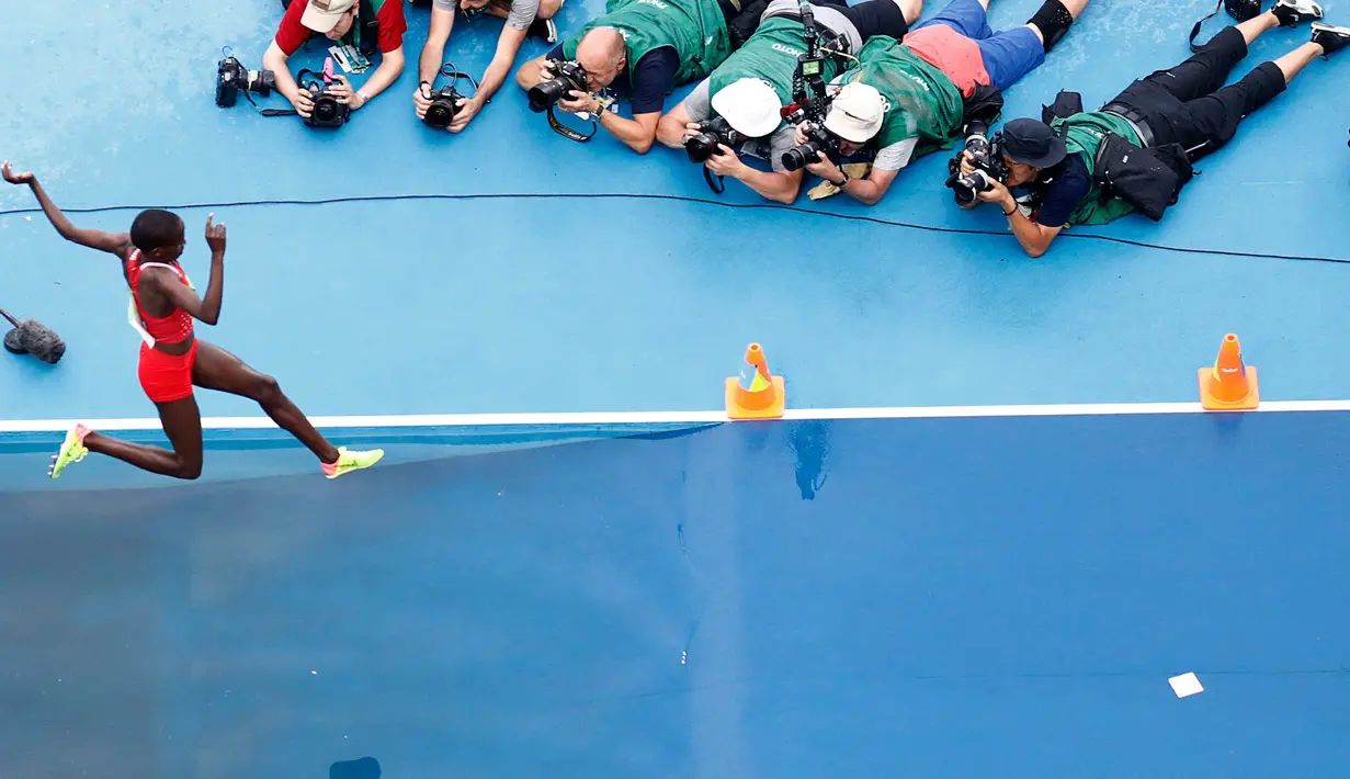 Sejumlah fotografer rela tengkurap demi mendapatkan momen foto terbaik pada lari halang rintang 3000 meter wanita Olimpiade Rio 2016 di Olympic Stadium, Rio de Janeiro, Brasil, (15/8). (REUTERS / Fabrizio Bensch)