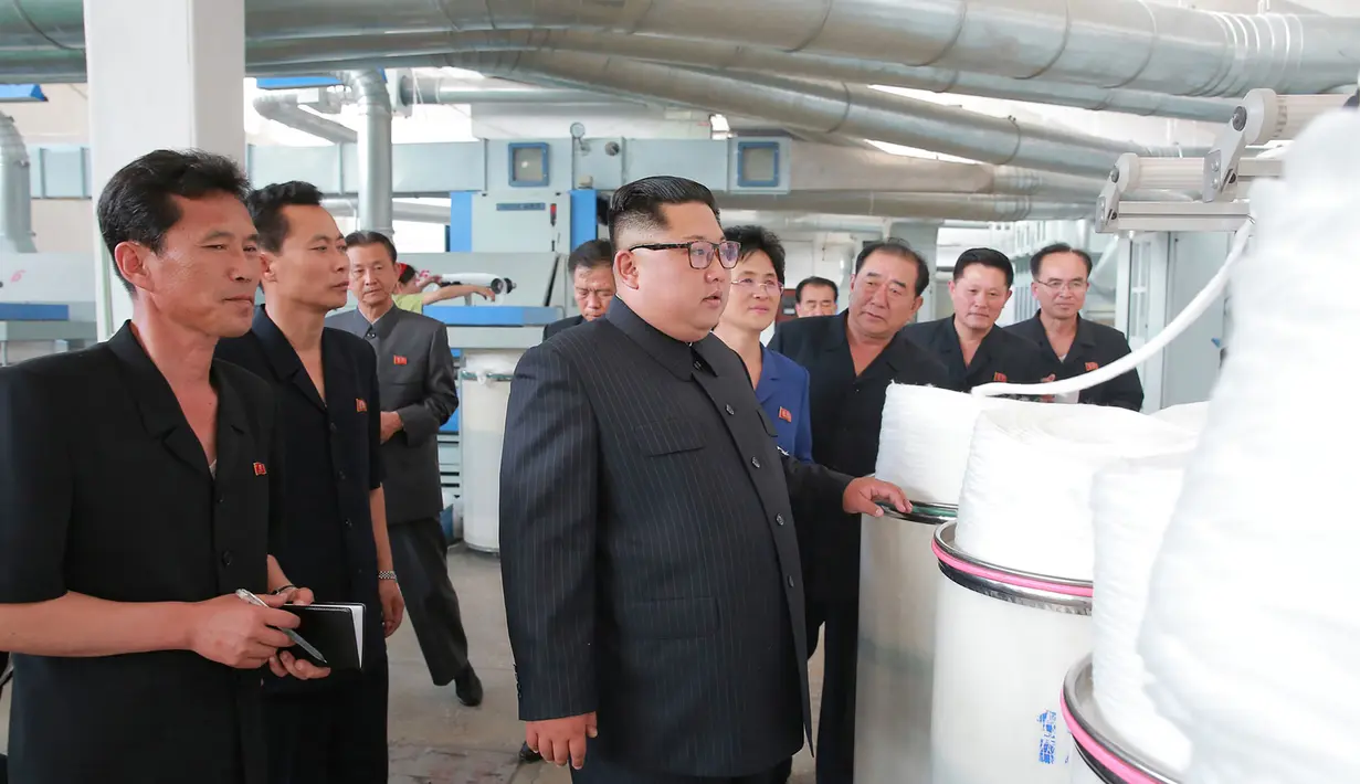 Pemimpin Korea Utara, Kim Jong-un mengecek pabrik tekstil di Sinuiju, Korea Utara (2/7). (AFP Photo/KCNA Via KNS)