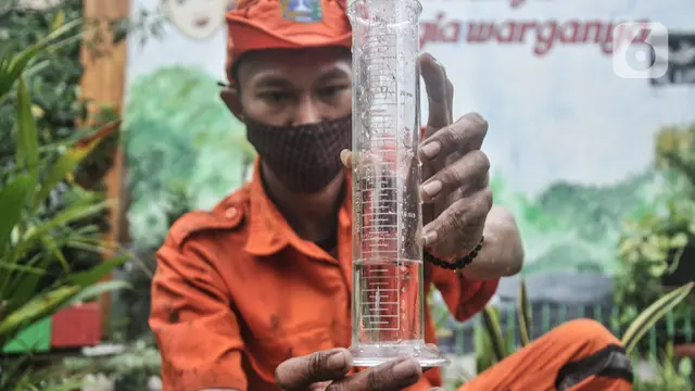 Petugas PPSU menunjukan tabung pengukur curah hujan di Kantor Kelurahan Sunter Agung, Jakarta, Senin (18/10/2021).