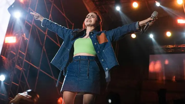 Momo Geisha dengan semangat mengajak penggemarnya untuk nyanyi bersama. Ia pun mengarahkan mic nya ke penonton. (Foto: Instagram/@therealmomogeisha)