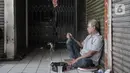 Seorang pedagang duduk di depan toko yang tutup di Pasar Rawamangun, Jakarta, Minggu (28/6/2020). Penutupan dilakukan setelah satu orang pedagang positif Covid-19 berdasarkan hasil tes usap atau swab beberapa waktu lalu. (merdeka.com/Iqbal S. Nugroho)