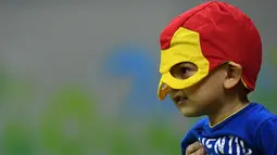 Seorang anak kecil menggunakan atribut unik di kepalanya saat menyaksikan pertandingan bola tangan antara Rusia vs Swedia dalam ajang Olimpiade 2016, di Rio de Janeiro, 10 Agustus 2016. (AFP PHOTO/Franck FIFE)