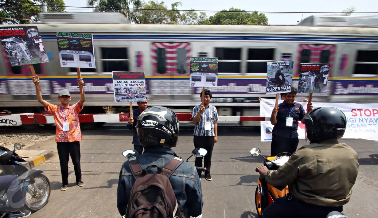 Komunitas Indonesian Railway Preservation Society melakukan aksi Kampanye Keamanan Perlintasan Sebidang Kereta Api di Menteng, Jakarta, Kamis (15/10). Kampanye itu guna menyadarkan bahaya menerobos perlintasan kereta api. (Liputan6.com/Immanuel Antonius)