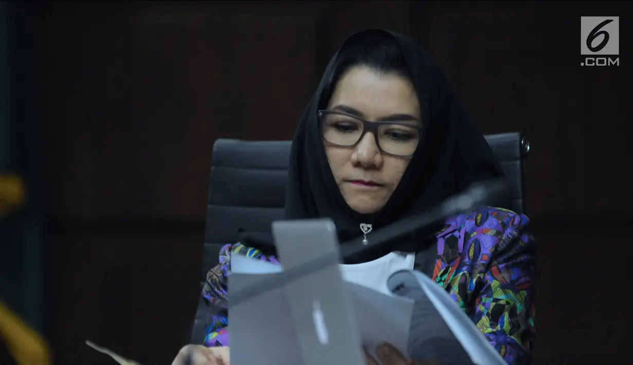 Terdakwa gratifikasi dan suap pemberian izin lokasi perkebunan kelapa sawit, Rita Widyasari membaca berkas saat mengikuti sidang lanjutan di Pengadilan Tipikor, Jakarta, Rabu (11/4). Sidang mendengar keterangan saksi. (Liputan6.com/Helmi Fithriansyah)