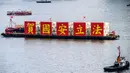 Kapal tongkang dengan spanduk bertuliskan “Rayakan Hukum Keamanan Nasional” berlayar di Victoria Harbour pada peringatan 23 tahun penyerahan Hong Kong dari Inggris ke China di Hong Kong, Rabu (1/7/2020). Hong Kong menandai 23 tahun penyerahan dari Inggris ke Cina pada 1 Juli. (Anthony WALLACE/AFP)