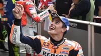 Pebalap tim MotoGP Repsol Honda Marc Marquez tersenyum saat menyapa fans setelah kualifikasi MotoGP Thailand 2018 di Sirkuit Internasional Buriram (6/10). Marquez menorehkan waktu tercepat dengan catatan waktu 1.30.088. (AFP Photo/Lillian Suwanrmpha)