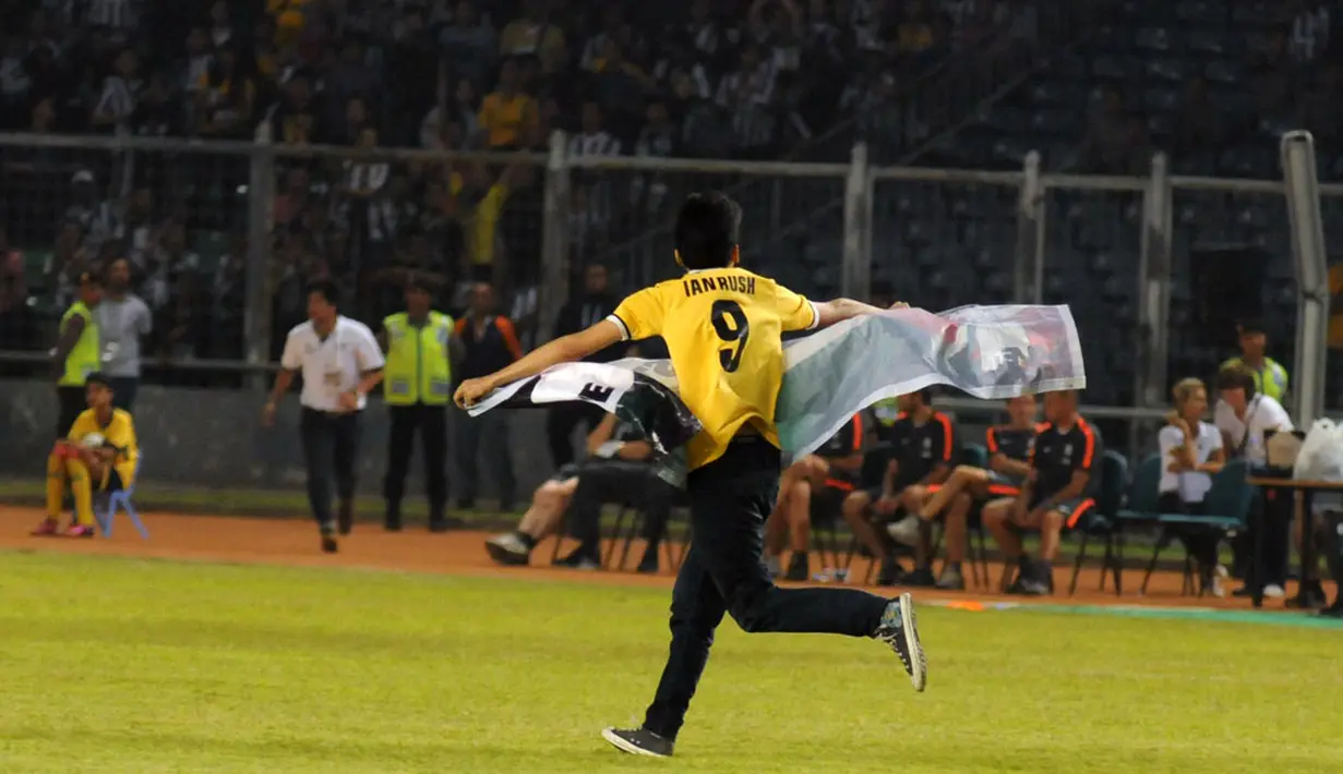 Salah satu suporter yang menyaksikan laga persahabatan ISL All Stars vs Juventus nekat memasuki lapangan Stadion GBK, Jakarta, (6/8/2014). (Liputan6.com/Helmi Fithriansyah)