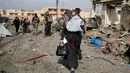 Seorang wanita menutupi wajahnya saat berusaha menyelamatkan diri menyusul serangan bom mobil bunuh diri yang dilakukan militan ISIS di kota Tahrir, Irak, 17 November 2016. (REUTERS/Goran Tomasevic)