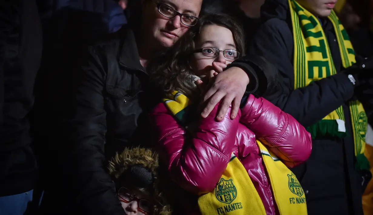 Ekspresi pendukung FC Nantes yang larut dalam kedukaan. Hal tersebut terjadi setelah mendengar kabar mantan bintang mereka, Emiliano Sala tewas karena pesawat yang ditumpanginya hilang dari kontak. (AFP/Loic Venance)