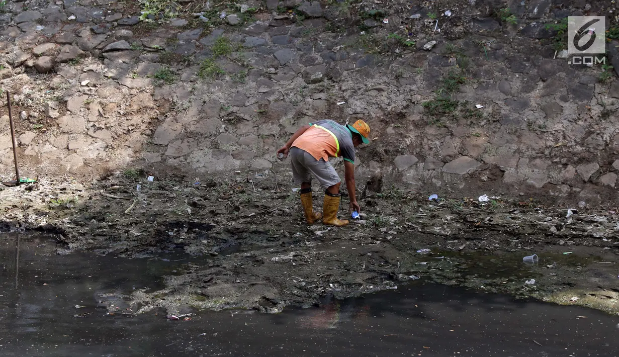 Pekerja dari UPK Badan Air Dinas Kebersihan DKI Jakarta memunguti sampah di salah satu sisi Kali Cideng kawasan Epicentrum Kuningan, Jakarta, Kamis (20/6/2019). Pencangkulan ini untuk menghilangkan endapan lumpur dan memperlancar arus air. (Liputan6.com/Helmi Fithriansyah)