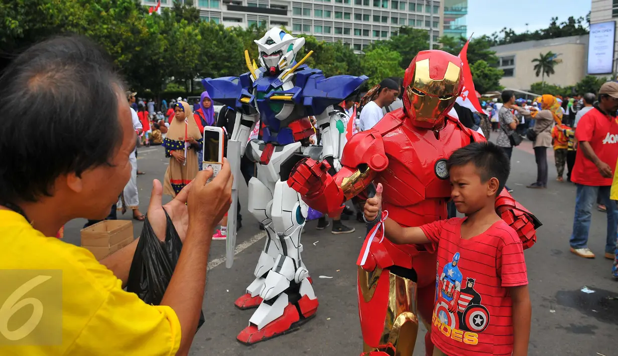 Seorang anak berfoto bersama tokoh robot Iron Man yang meramaikan parade kebudayaan 'Kita Indonesia' di Bundaran HI, Jakarta, Minggu (4/12). Tokoh superhero hingga animasi menjadi incaran peserta parade kebudayaan untuk berfoto (Liputan6.com/Angga Yuniar)