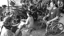 Penyandang disabilitas Catur Bambang (45) berbincang saat menyelesaikan pembuatan sepeda motor roda tiga di bengkelnya, Jalan Wijaya Kusuma, Ciputat Timur, Tangerang Selatan, Banten, Selasa (5/11/2019). Catur mampu membuat 2-3 sepeda motor roda tiga dalam seminggu. (merdeka.com/Arie Basuki)