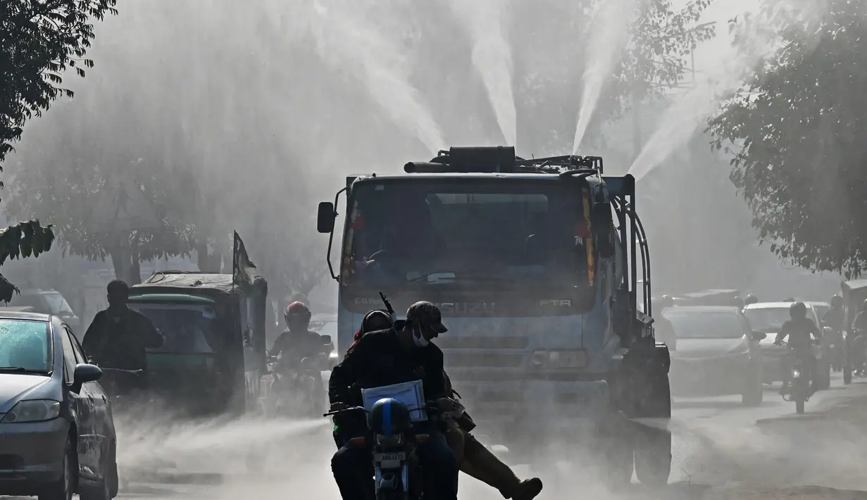 Sebuah kendaraan Badan Air dan Sanitasi (WASA) menyemprotkan air dengan menggunakan pistol anti-kabut asap untuk mengurangi polusi udara di tengah kondisi kabut asap tebal di Lahore, Pakistan pada 19 November 2024. (Arif ALI/AFP)