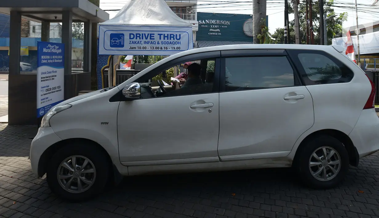 Panitia zakat fitra melakukan pengisian data di Masjid Nurul Hidaya, Jakarta, Sabtu (16/5/2020). Di tengah pandemi Covid-19 panitia masjid membuat lokasi penerima zakat dengan drive thru. (merdeka.com/Imam Buhori)