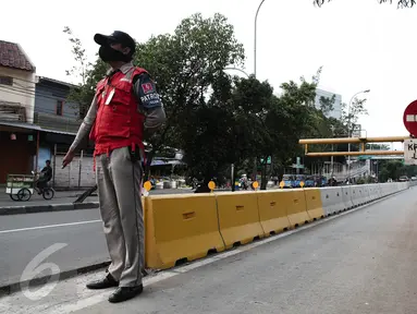 Petugas TransJakarta menjaga jalur busway dikawasan Pramuka, Jakarta, Minggu (12/6/2016). Pemprov DKI Jakarta akan melakukan sterilisasi jalur Trans Jakarta mulai Senin nanti (13/6). (Liputan6.com/Faizal Fanani)