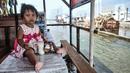 Seorang anak duduk di meja warung saat banjir rob di Pelabuhan Kali Adem, Muara Angke, Jakarta, Kamis (22/10/2020). Banjir akibat air pasang dengan ketinggian mencapai 30 cm tersebut telah merendam kawasan Pelabuhan Kali Adem dan sudah berlangsung selama lima hari. (merdeka.com/Iqbal S. Nugroho)