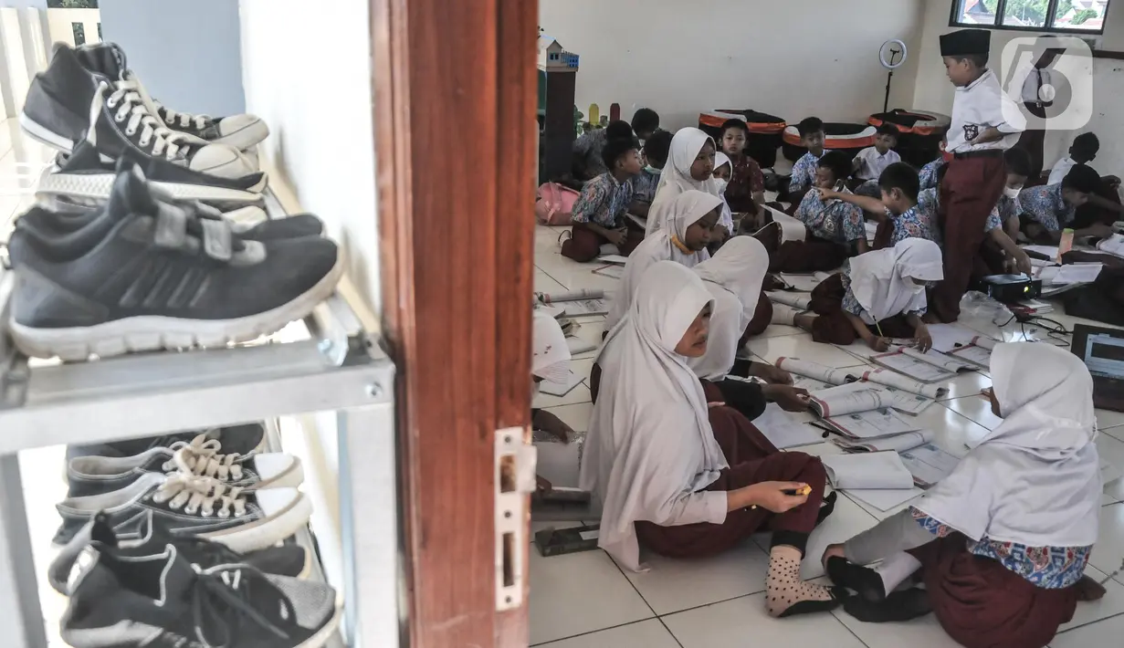 Aktivitas murid saat belajar tanpa fasilitas meja dan kursi di salah satu kelas Sekolah Dasar Negeri (SDN) Mekarsari 05, Tambun Selatan, Kabupaten Bekasi, Jawa Barat, Kamis (28/7/2022). Sudah dua pekan berlangsung sejak dimulainya Tahun Ajaran Baru 2022 murid kelas IV dan V di SDN Mekarsari 05 mengikuti kegiatan belajar tanpa fasilitas meja dan kursi. (merdeka.com/Iqbal S. Nugroho)
