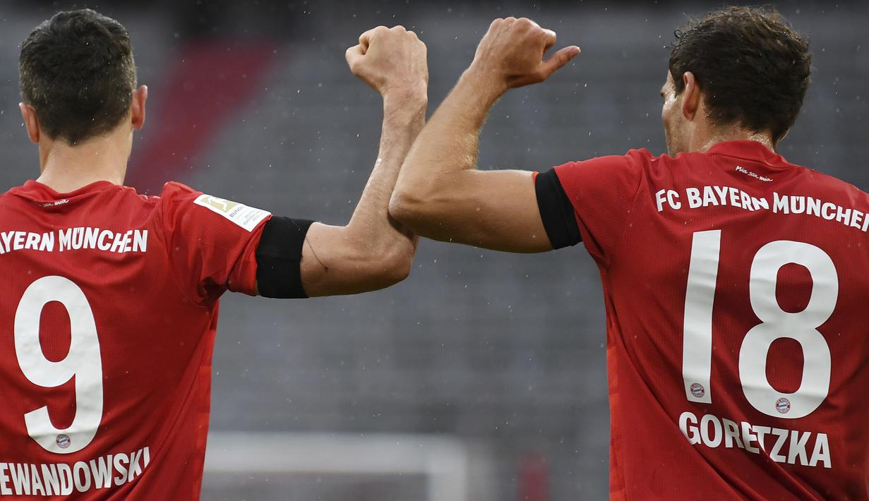 Pemain Bayern Munchen, Robert Lewandowski dan Leon Goretzka melakukan selebrasi usai membobol gawang Eintracht Frankfurt pada laga Bundesliga di Allianz Arena, Minggu (24/5/2020). Bayern Munchen menang 5-2 atas Eintracht Frankfurt. (AP/Andreas Gebert)