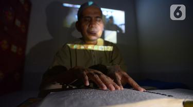 Seorang tunanetra membaca Al-Quran braille saat tadarus bersama secara online lewat aplikasi di Jakarta, Selasa (12/5/2020). Di tengah pandemi COVID-19 ini, sejumlah tunanetra melakukan tadarus bersama guna meningkatkan keimanan dan ketakwaan di bulan Ramadan 1441 Hijriah. (merdeka.com/Imam Buhori)