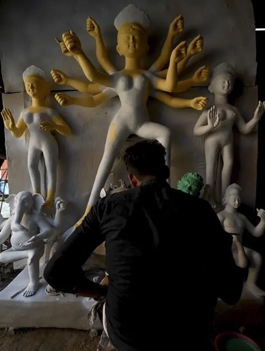 Seorang perajin mengerjakan pembuatan patung Dewi Durga jelang Festival Durga Puja di sebuah bengkel di New Delhi, India, Rabu (29/9/2021). (MONEY SHARMA/AFP)