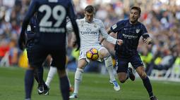 Toni Kroos (tengah) berusaha menerobos ketatnya pertahanan Malaga pada lanjutan La Liga di Santiago Bernabeu stadium, Madrid, Sabtu (21/1/2017). Madrid menang 2-1. (AP/Francisco Seco)