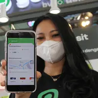 Model menunjukkan aplikasi Gojek melalui GoTransit saat peluncuran di Stasiun Juanda, Jakarta, Rabu (22/06/2022). Melalui kolaborasi antara Gojek, layanan on-demand ekosistem GoTo dan PT Kereta Commuter Indonesia (PT KCI), kedua perusahaan menghadirkan perjalanan full mile multi-moda terintegrasi untuk memudahkan masyarakat dan mendukung visi pemerintah dalam menggalakkan penggunaan transportasi publik. (Liputan6.com/HO/Ading)