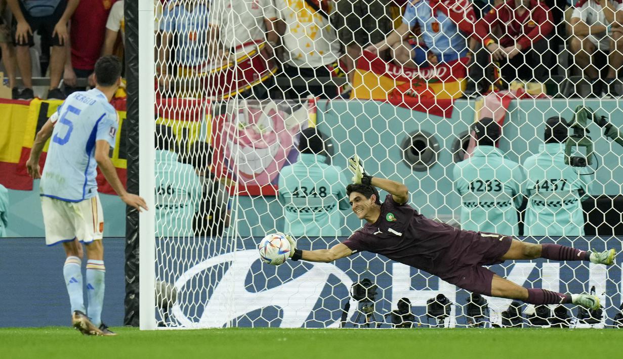 <p>Kiper Maroko,&nbsp;Yassine Bounou berhasil menghalau tendangan penalti dari pemain Spanyol, Sergio Busquets saat laga 16 besar Piala Dunia 2022 yang berlangsung di Education City Stadium, Selasa (06/12/2022). (AP/Francisco Seco)</p>