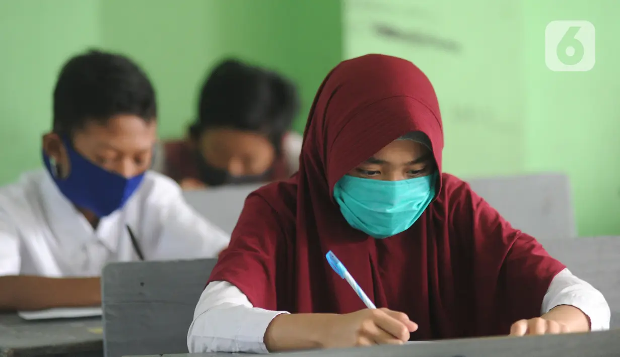 Murid baru menggunakan masker  mengikuti tes penentuan kelas tahun ajaran 2020-2021 yang selanjutnya akan mengikuti kegiatan belajar mengajar (KBM) secara darling di MTs Hidayatul Umami, Cinere, Depok, Jawa Barat, Senin (13/7/2020). (merdeka.com/Arie Basuk)