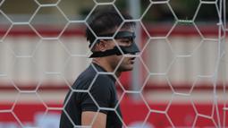 Andritany menggunakan masker pelindung wajah saat sesi latihan tim jelang laga Gojek Liga 1 bersama Bukalapak di Stadion PTIK, Jakarta, Senin (25/6/2018). Andritany berpeluang tampil saat Persija melawan Persebaya. (Bola.com/Nick Hanoatubun)