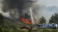 Petugas pemadam kebakaran dibantu beberapa helikopter pemadam dan helikopter militer Cocos di San Marcos, California, AS, Kamis (15/5/2014). (Reuters / mike blake)  