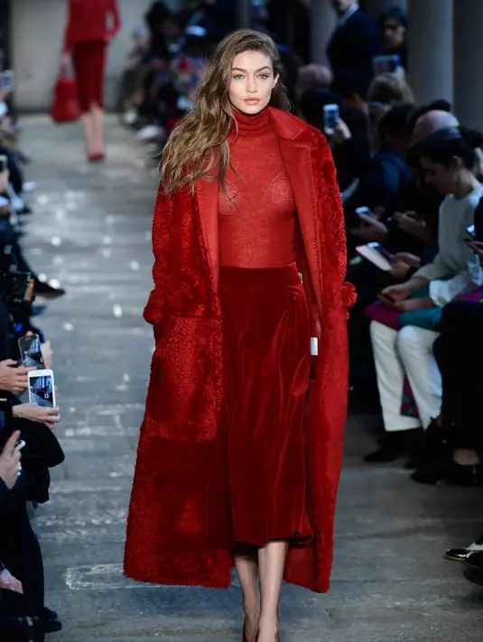 Gigi Hadid saat membawakan busana karya Max Mara selama Autumn / Winter 2017 di Milan Fashion Week, Italia (23/2). Gigi Hadid tampil cantik dan seksi dengan busana tipis berwarna merah. (AFP Photo / Miguel Medina)