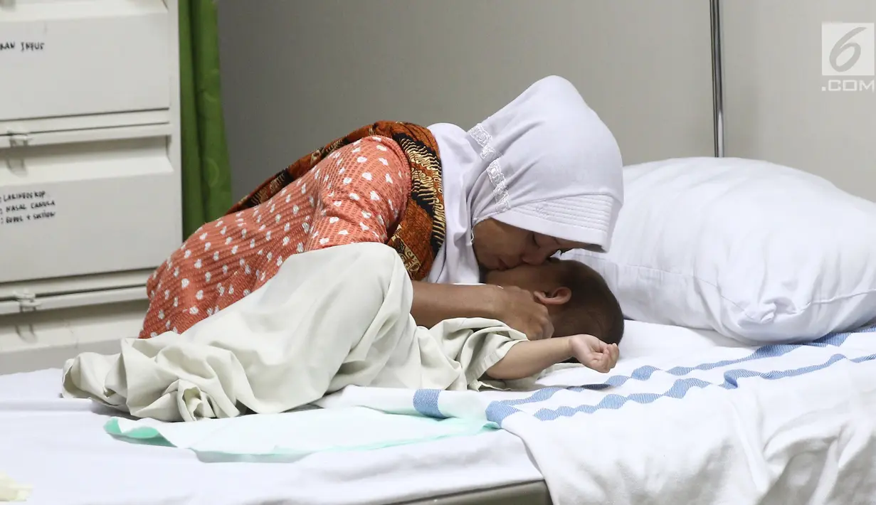 Orangtua pasien memeluk dan mencium anaknya sebelum masuk ruang operasi di RS EMC, Bogor, Jawa Barat, Sabtu (21/4). RS EMC menggelar operasi hernia kepada 60 pasien. (Liputan6.com/Herman Zakharia)