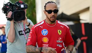 Pembalap Ferrari asal Inggris, Lewis Hamilton, berjalan di paddock pada hari pertama tes pramusim Formula Satu kedua di Sirkuit Internasional Bahrain di Sakhir pada 18 Februari 2026. (Giuseppe CACACE/AFP)